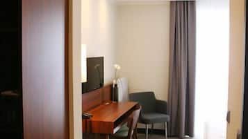 Una habitación de hotel con un escritorio de madera, una silla, un sofá y una cama.