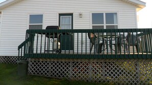 A white mobile home with a green porch and outdoor seating area. - Mayfield Country Cottages (Mayfield)