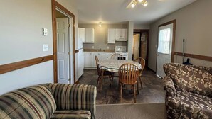 A compact living space with a dining area, kitchenette, and a ceiling fan. - Mayfield Country Cottages (Mayfield)