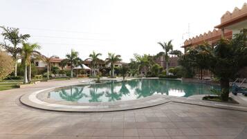 Una piscina al aire libre, sillones reclinables de piscina