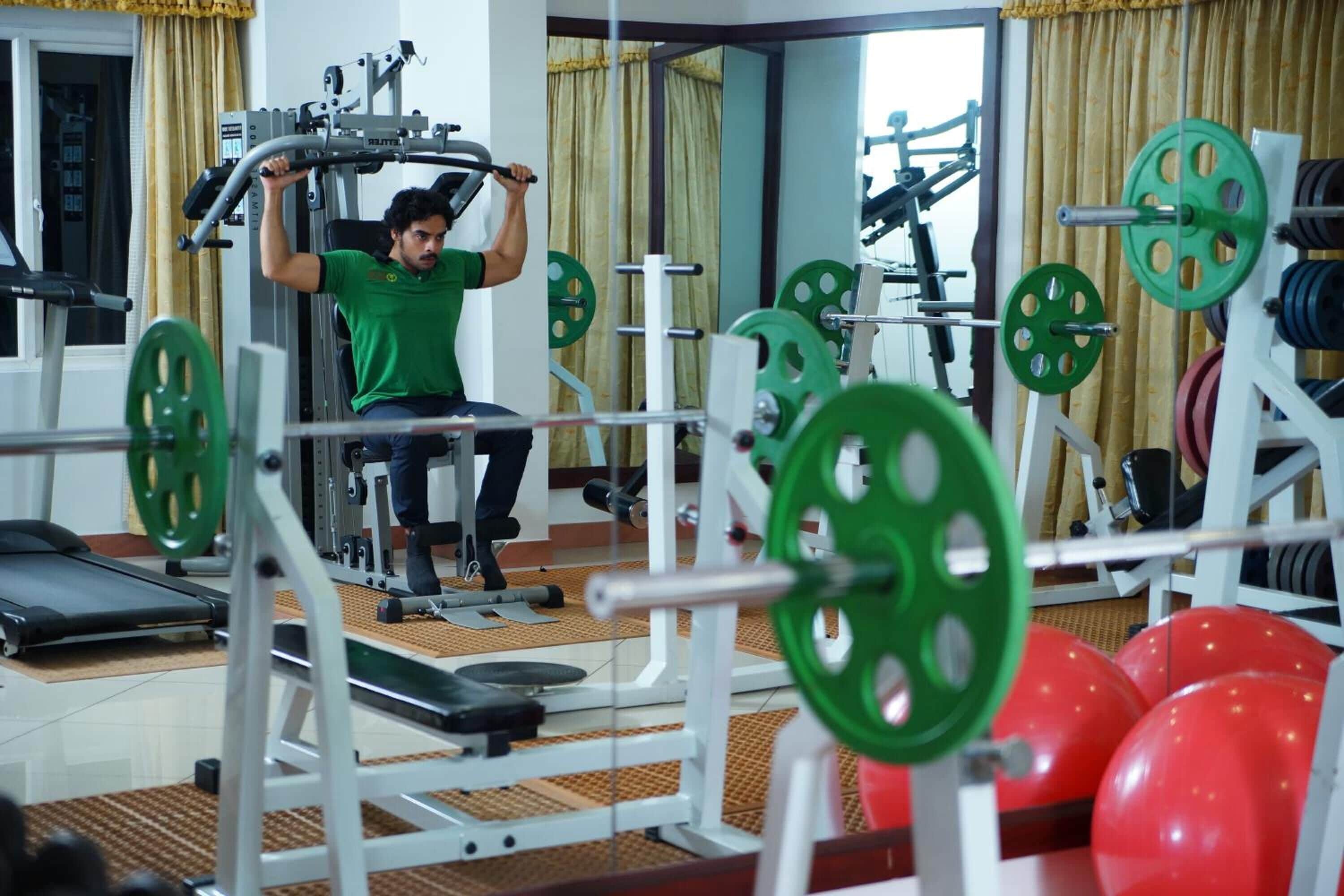 Un gimnasio con equipo de levantamiento de pesas y pelotas de ejercicio.
