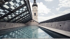 Una piscina interior con vistas a una torre y un cielo despejado.
