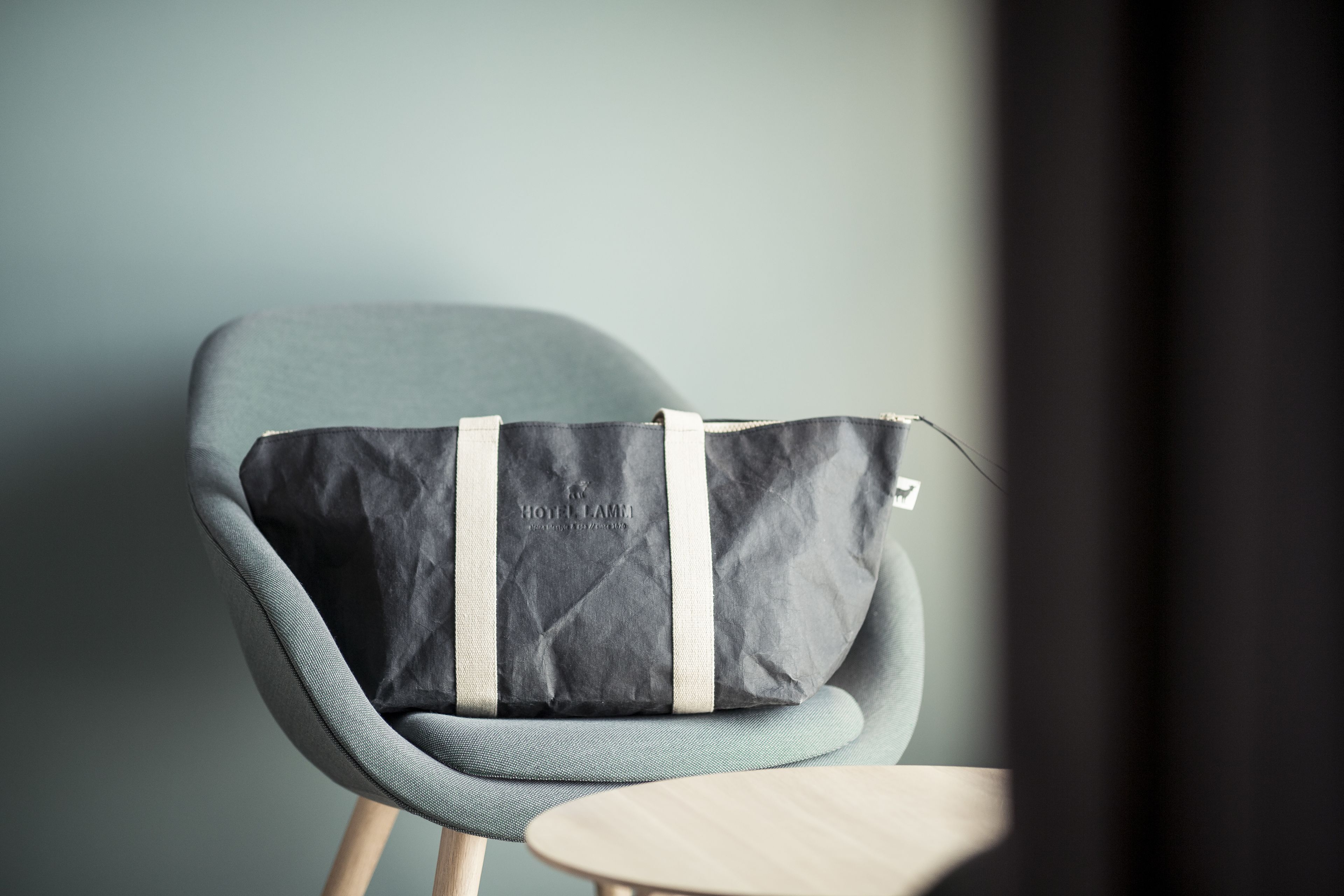 A chair with a black and grey bag on it.