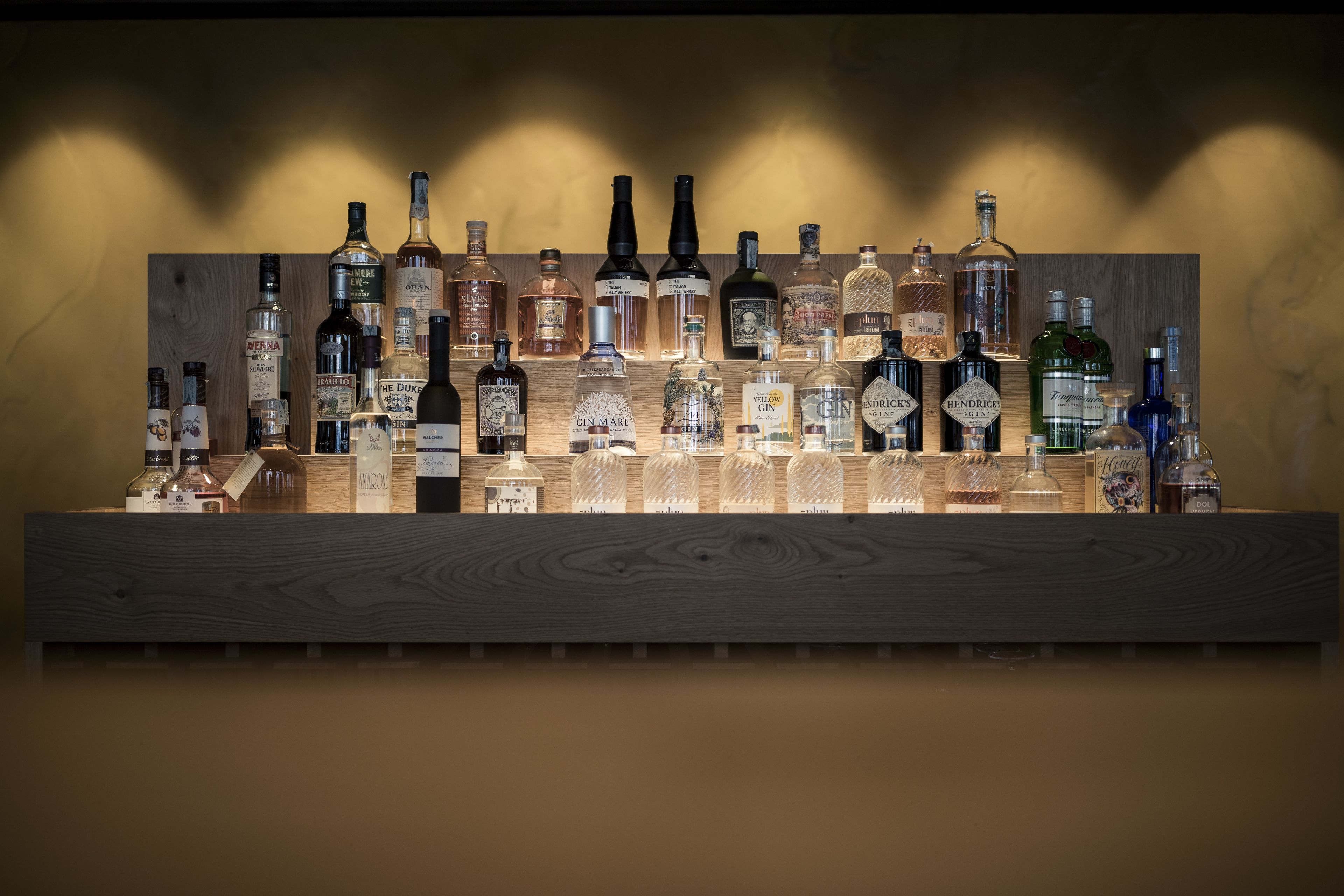 Un espace bar avec différentes bouteilles d’alcool et des verres.
