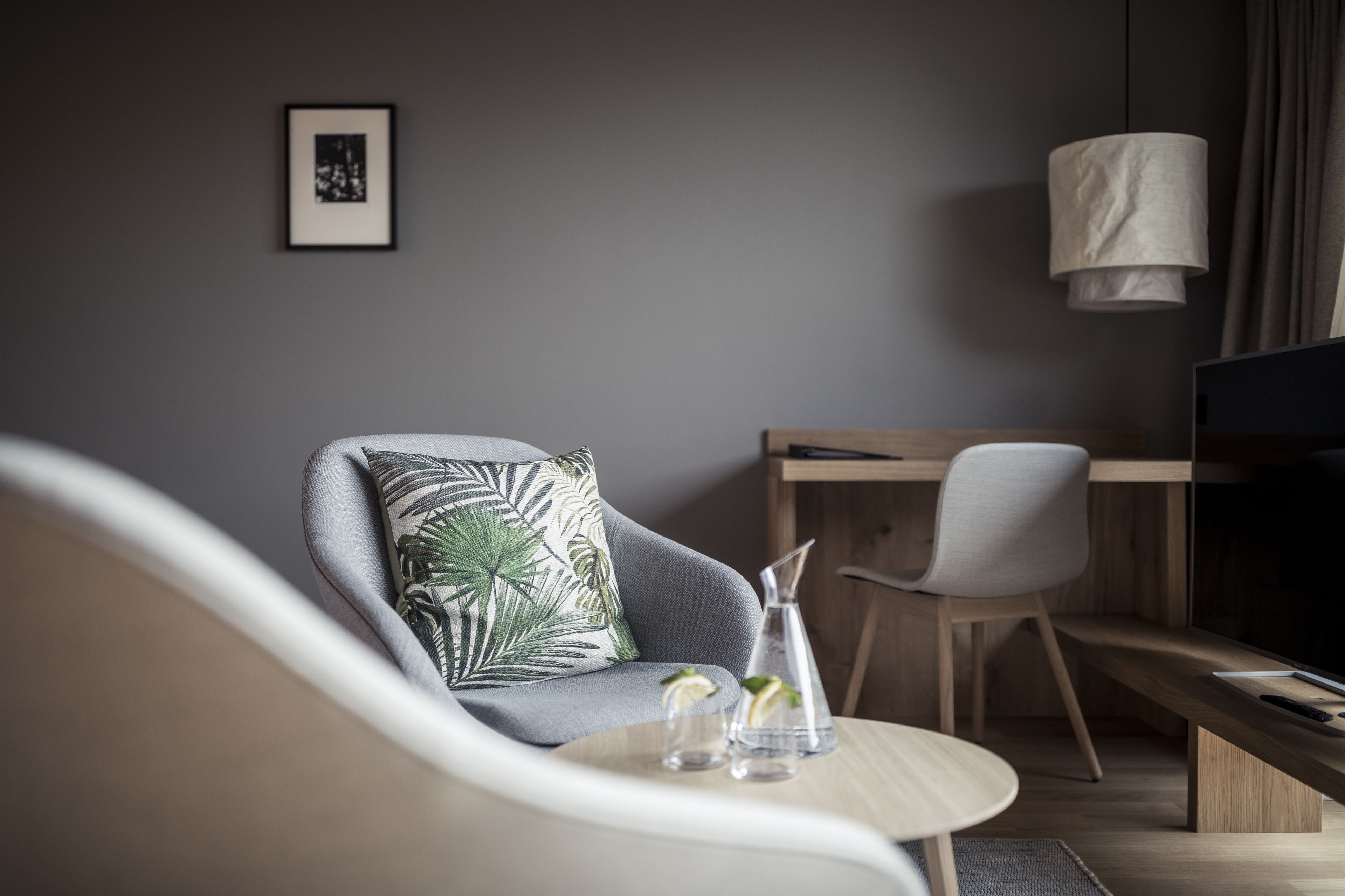 Un salon moderne avec un canapé gris, une table basse en bois et un meuble pour la télévision.