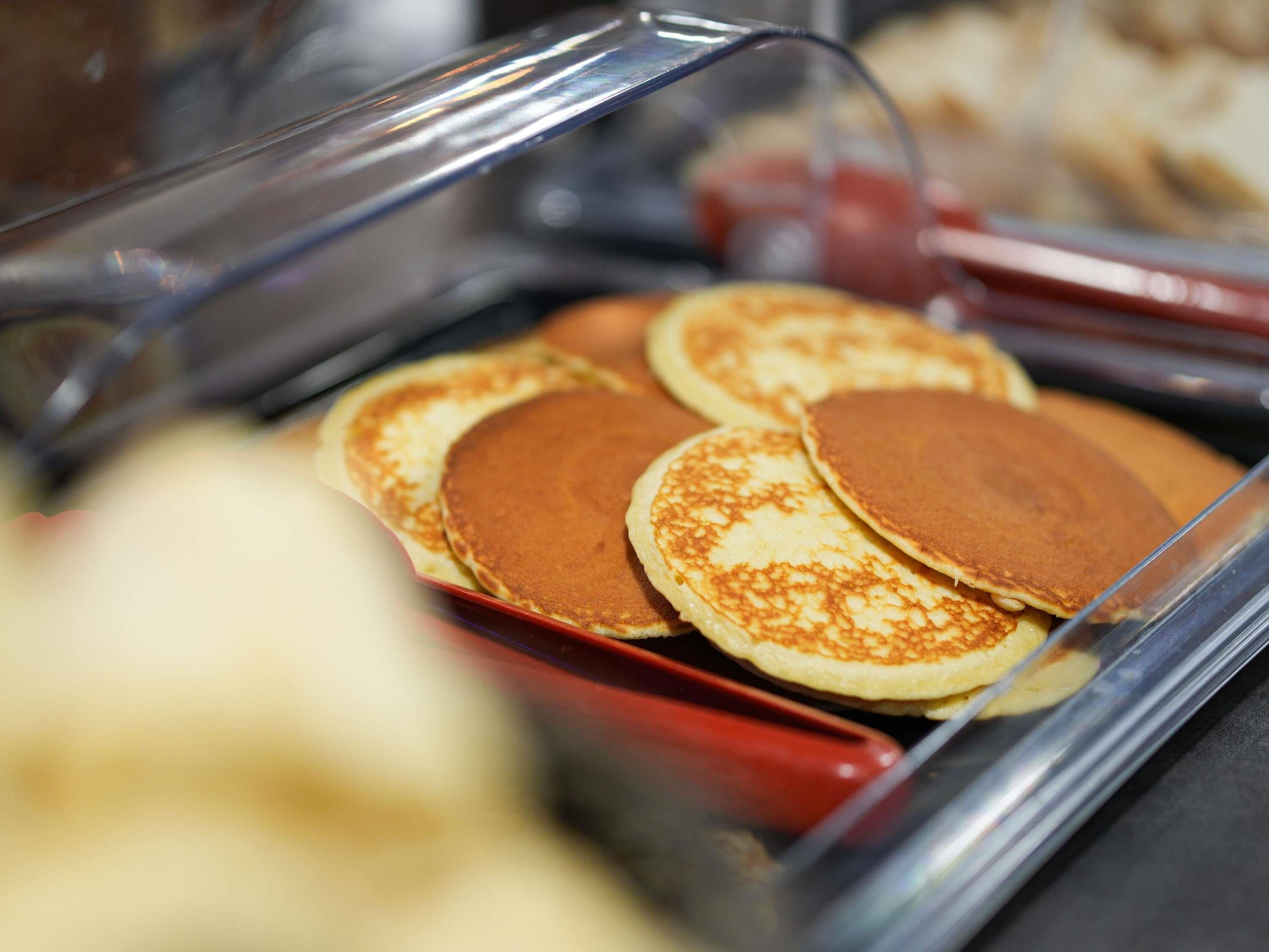 Een buffet met pannenkoeken en andere ontbijtartikelen.