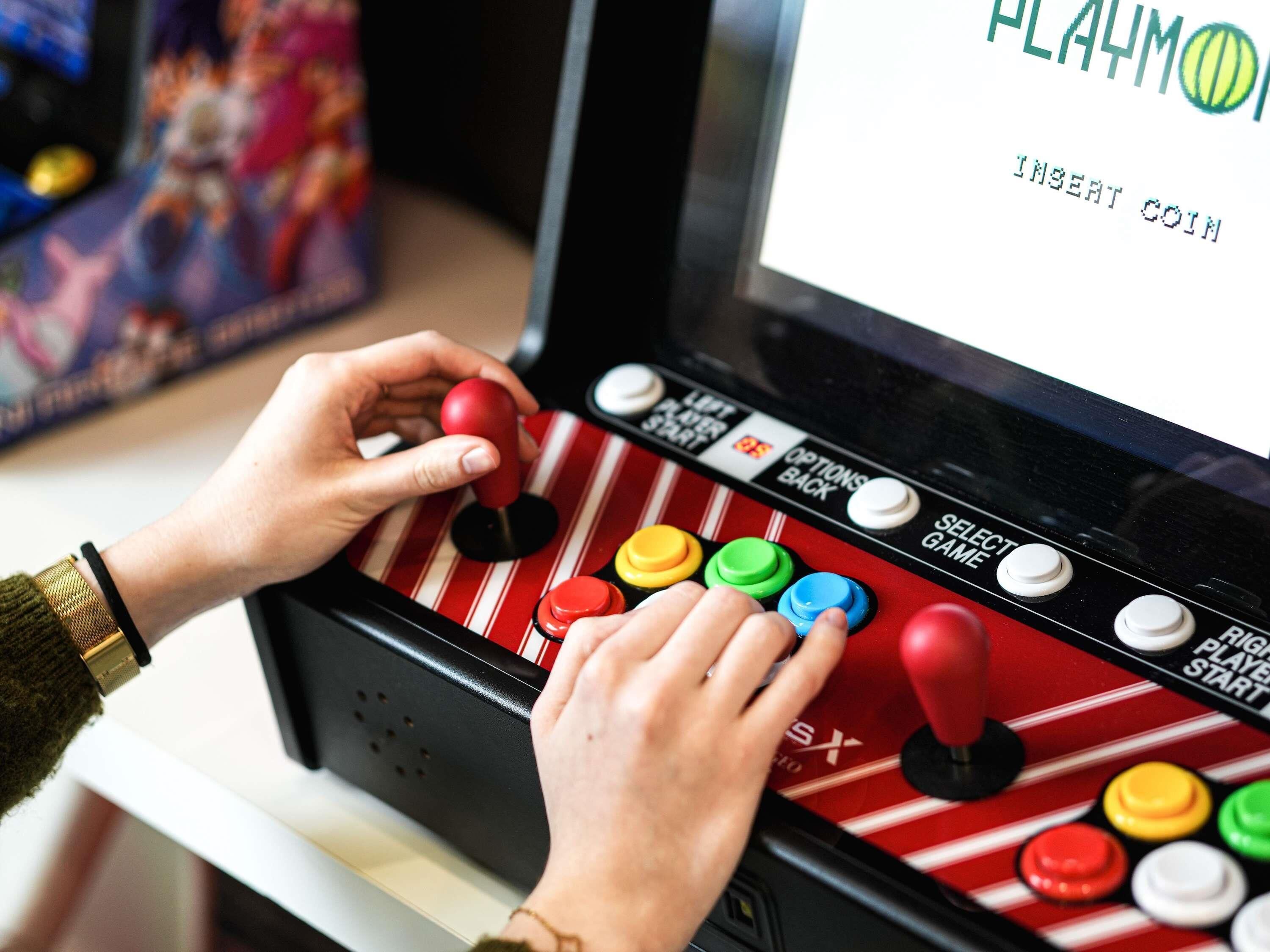 Una persona jugando un videojuego con un joystick y botones.