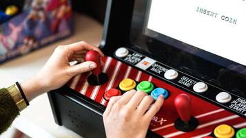 Una persona jugando un videojuego con un joystick y botones.