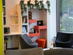 Una sala de estar moderna con una estantería, una mesa de centro y dos sillones.