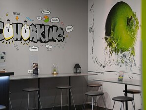 Un espacio de trabajo moderno con un mural de grafiti, taburetes de bar y un cuadro abstracto grande.