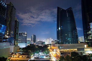 A cityscape at night with modern high-rise buildings and illuminated streets.