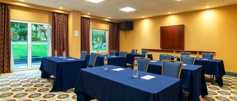 A conference room with tables set for meetings, equipped with water bottles and notepads.