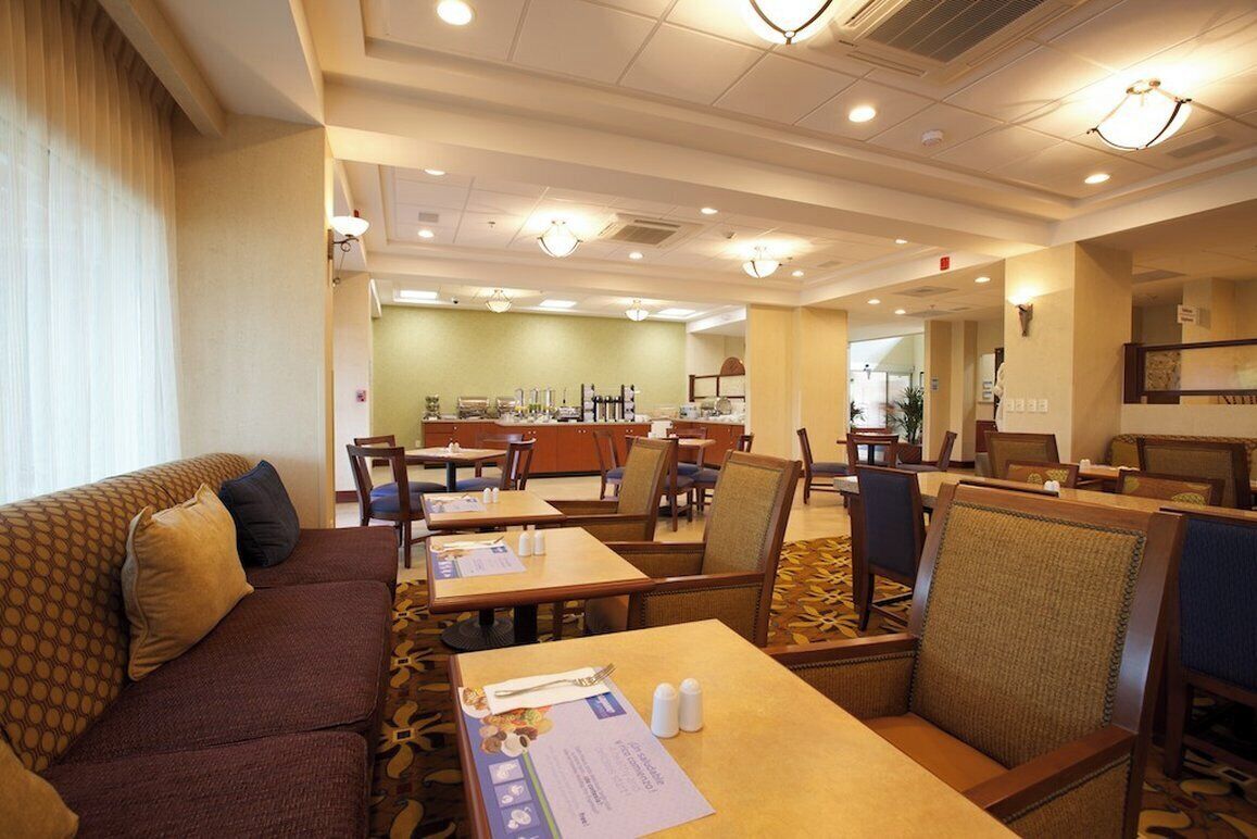 Un comedor de hotel con mesas, sillas y un sofá.