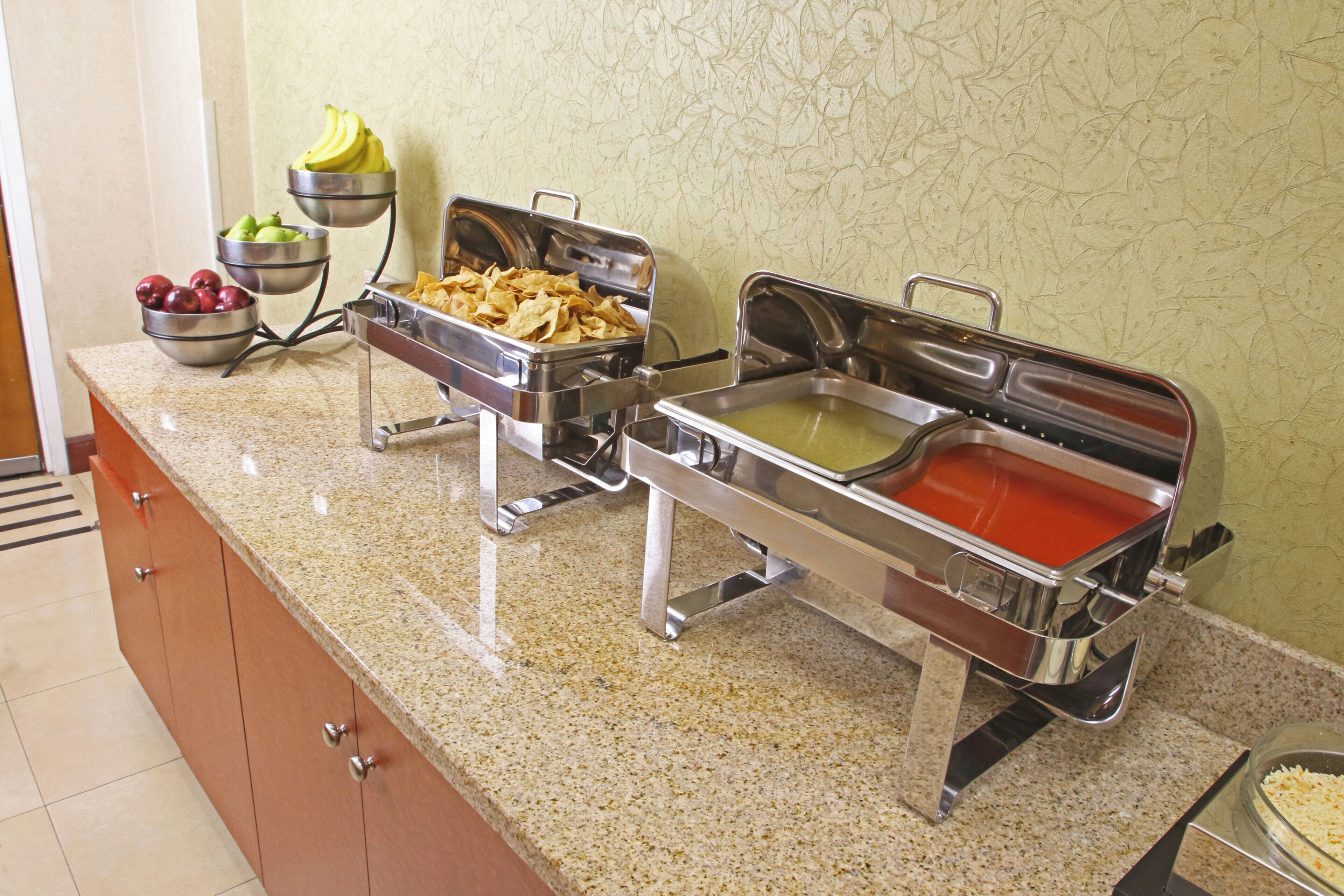 Una mesa de buffet con diversas opciones de comida y un frutero.