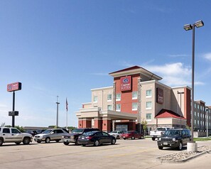 A Comfort Suites hotel with a parking lot filled with cars. - Comfort Suites Minot South (Minot)