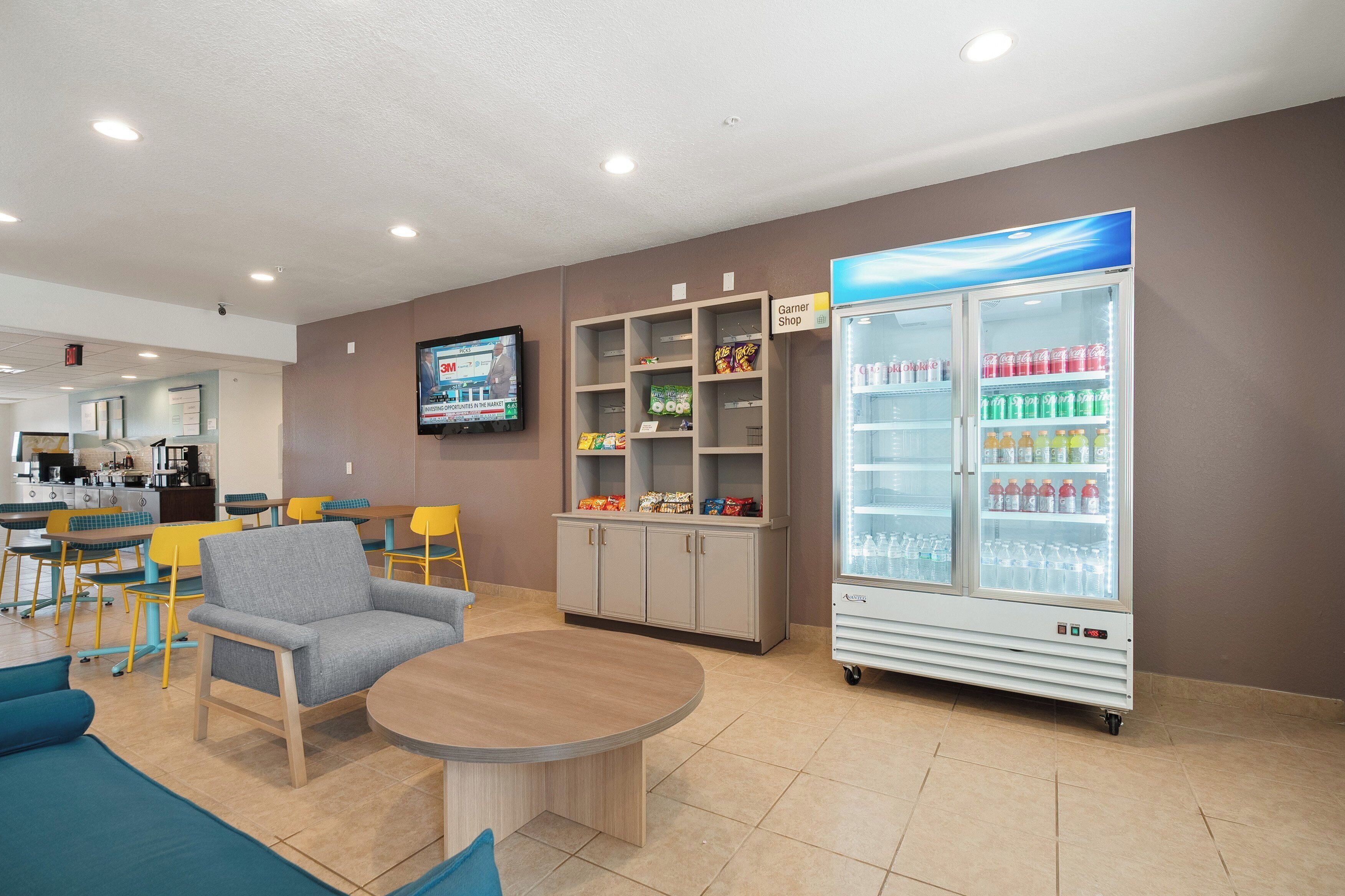 A lobby with seating, a snack bar, a television, and a beverage refrigerator.