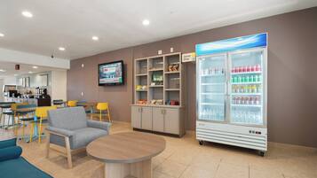 A lobby with seating, a snack bar, a television, and a beverage refrigerator.