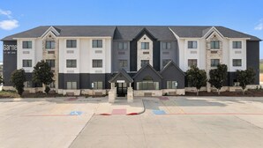 A multi-story hotel with a symmetrical facade, stone accents, and a central entrance.