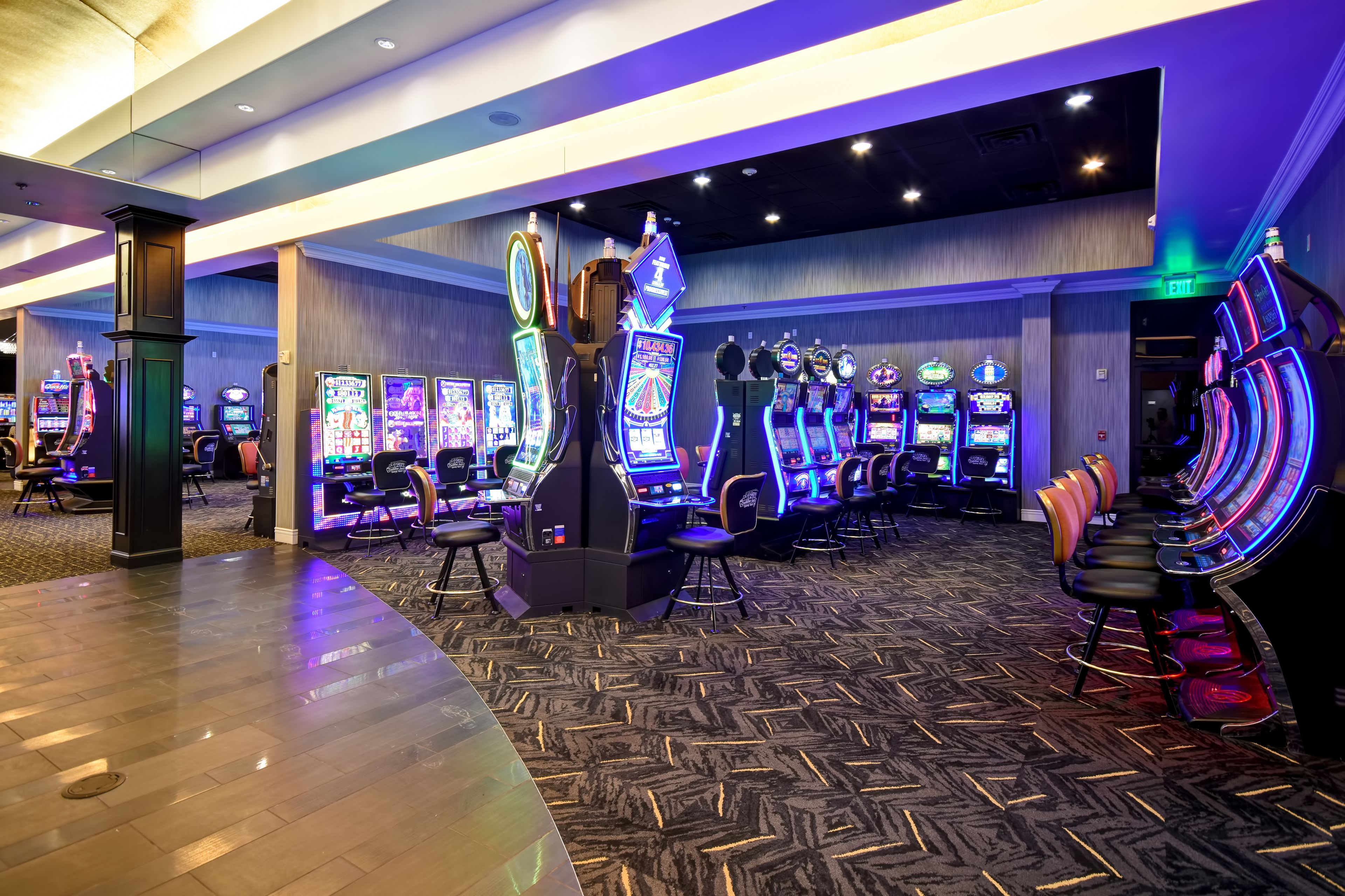 Zona de juegos con varias máquinas recreativas y asientos.