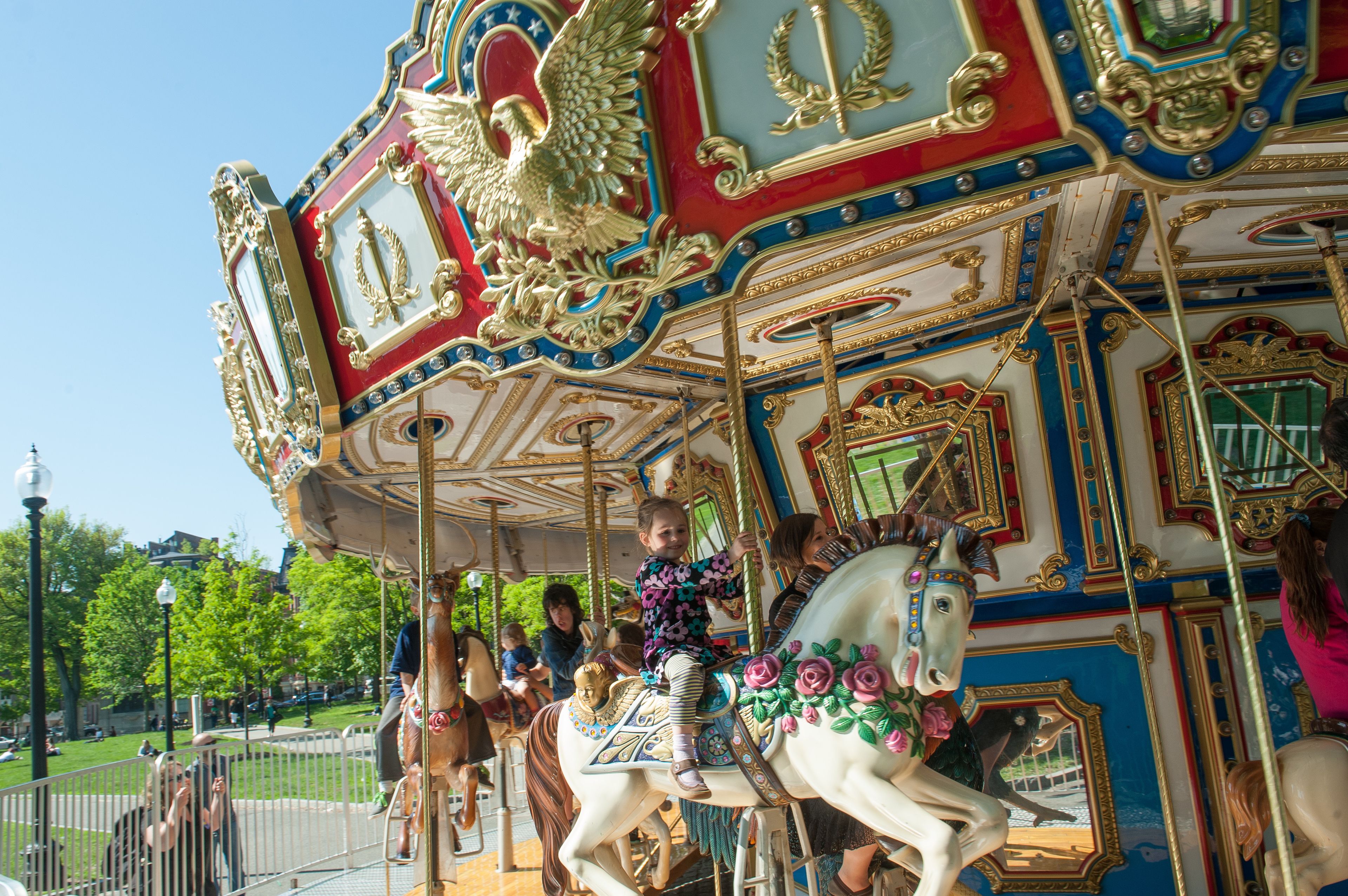 A carousel with ornate golden and red decorations, featuring a horse figure and riders.