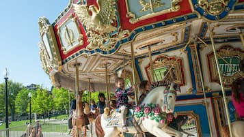 A carousel with ornate golden and red decorations, featuring a horse figure and riders.