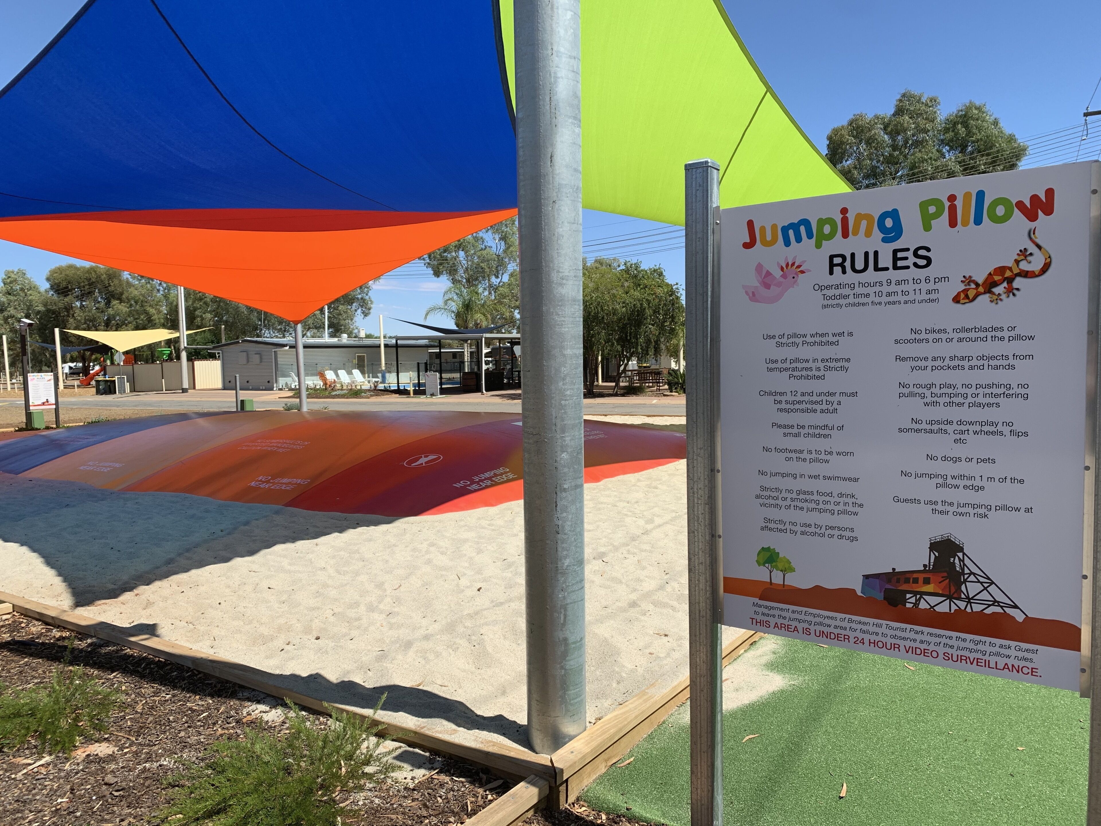 A jumping pillow area with rules and operating hours.