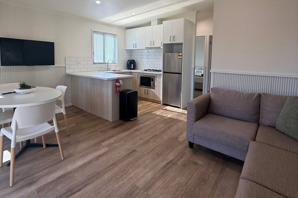 Una cocina moderna con armarios blancos, una isla central y un horno empotrado.