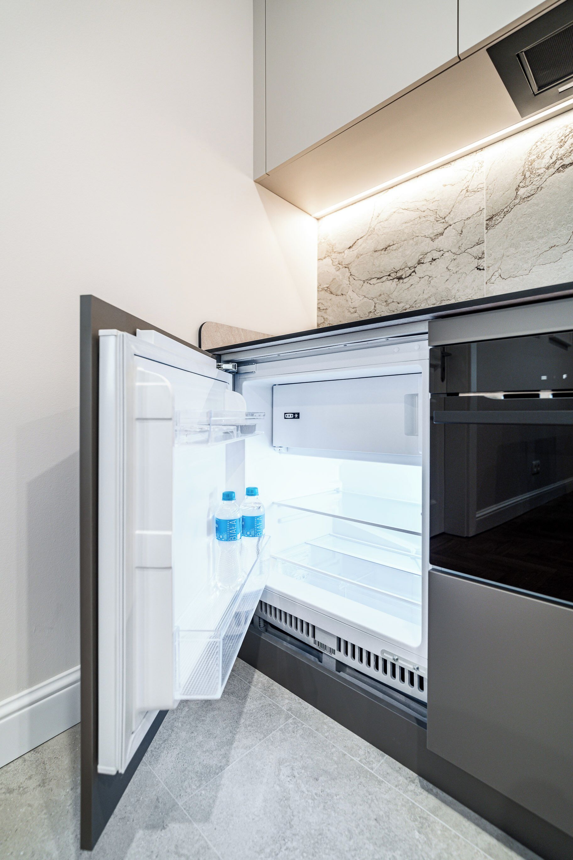Una cocina moderna con refrigerador incorporado, microondas y estufa.