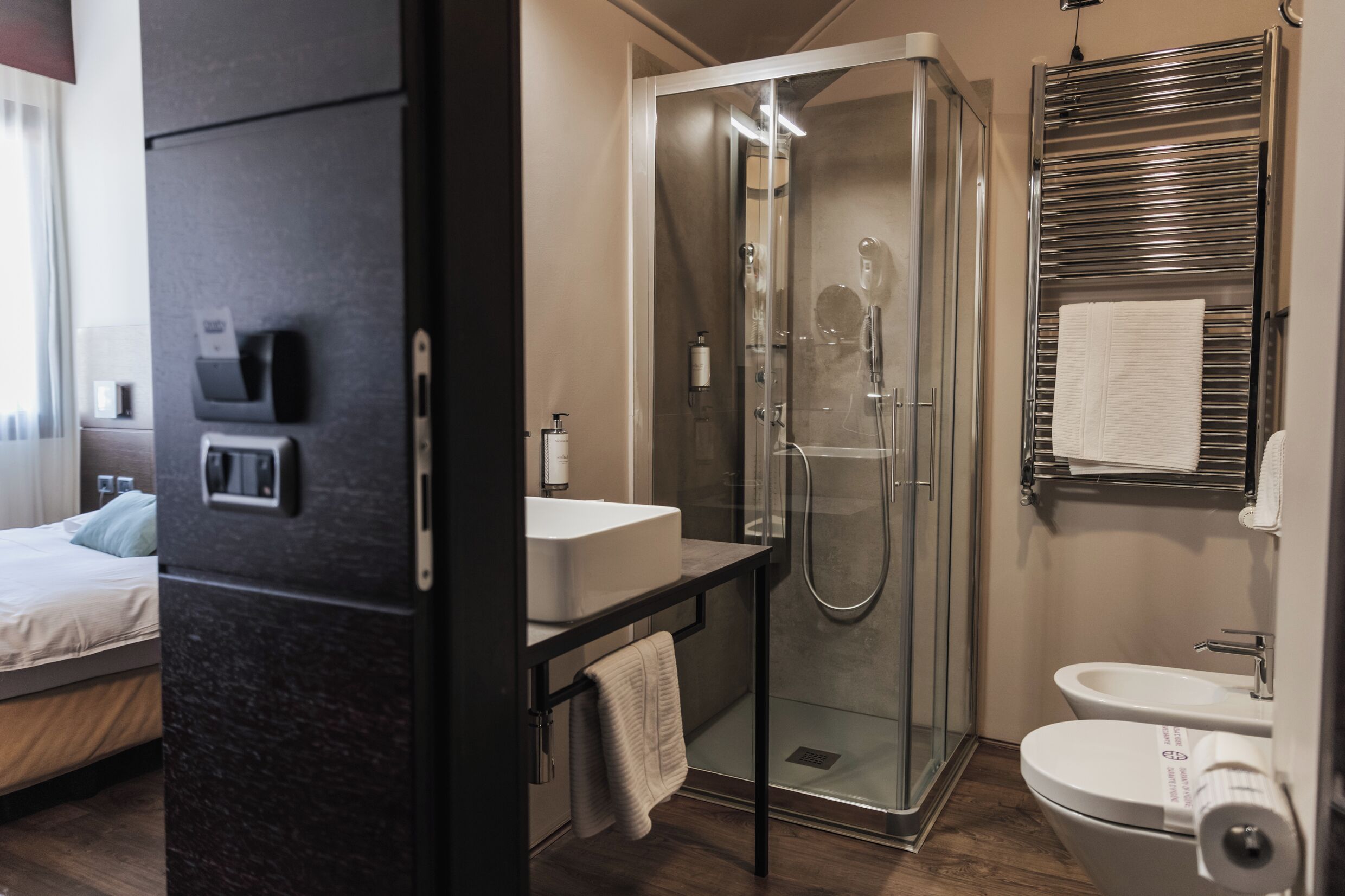 Un baño moderno con ducha de vidrio, lavamanos e inodoro.