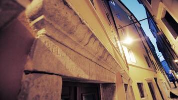 Primer plano de la esquina de un edificio con detalles de piedra labrada y una puerta.