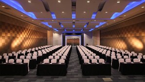 A conference room with rows of tables and chairs, a checkered wall pattern, and a blue-lit ceiling. - ALU Hotel Davao (Davao)