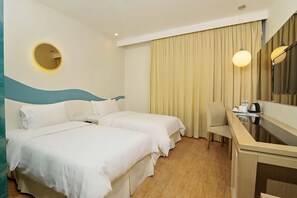 A hotel room with two beds, a desk, a chair, a round mirror, and a curtain. - Oceania Hotel (Kota Kinabalu)