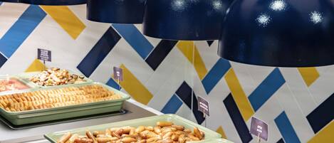 A buffet with various food items including sausages, bacon, and scrambled eggs.