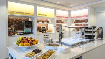 A breakfast buffet with various food items and a coffee machine.