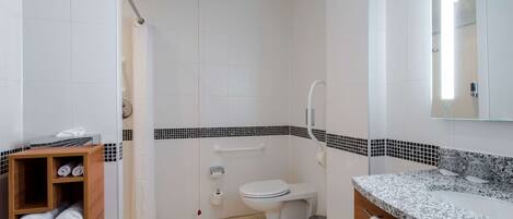 A modern bathroom with a shower, toilet, and sink.