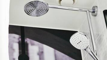 A shower with a handheld showerhead and a fixed showerhead mounted on a chrome bar.