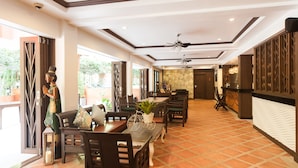 A hotel lobby with a reception desk, seating area, and a decorative statue.