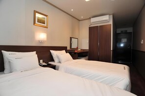A hotel room with two beds, a bedside table with a lamp, a mirror, and an air conditioning unit. - City Days Inn Dongdaemun (Seoul)