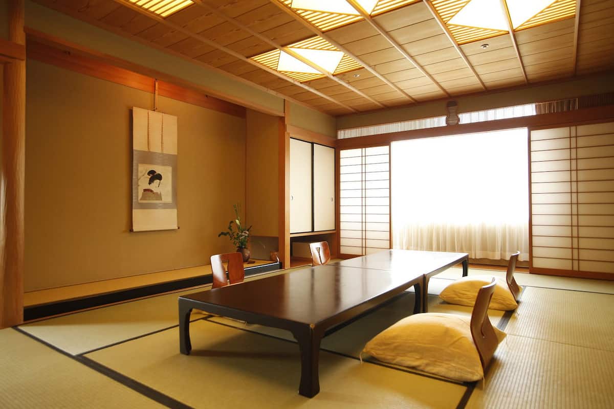 Una habitació japonesa tradicional amb tatami, una taula baixa i portes corredisses.