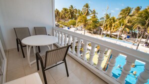 A balcony with a white balustrade, a round table, and two chairs. - Hotel El Dorado (San Andrés)