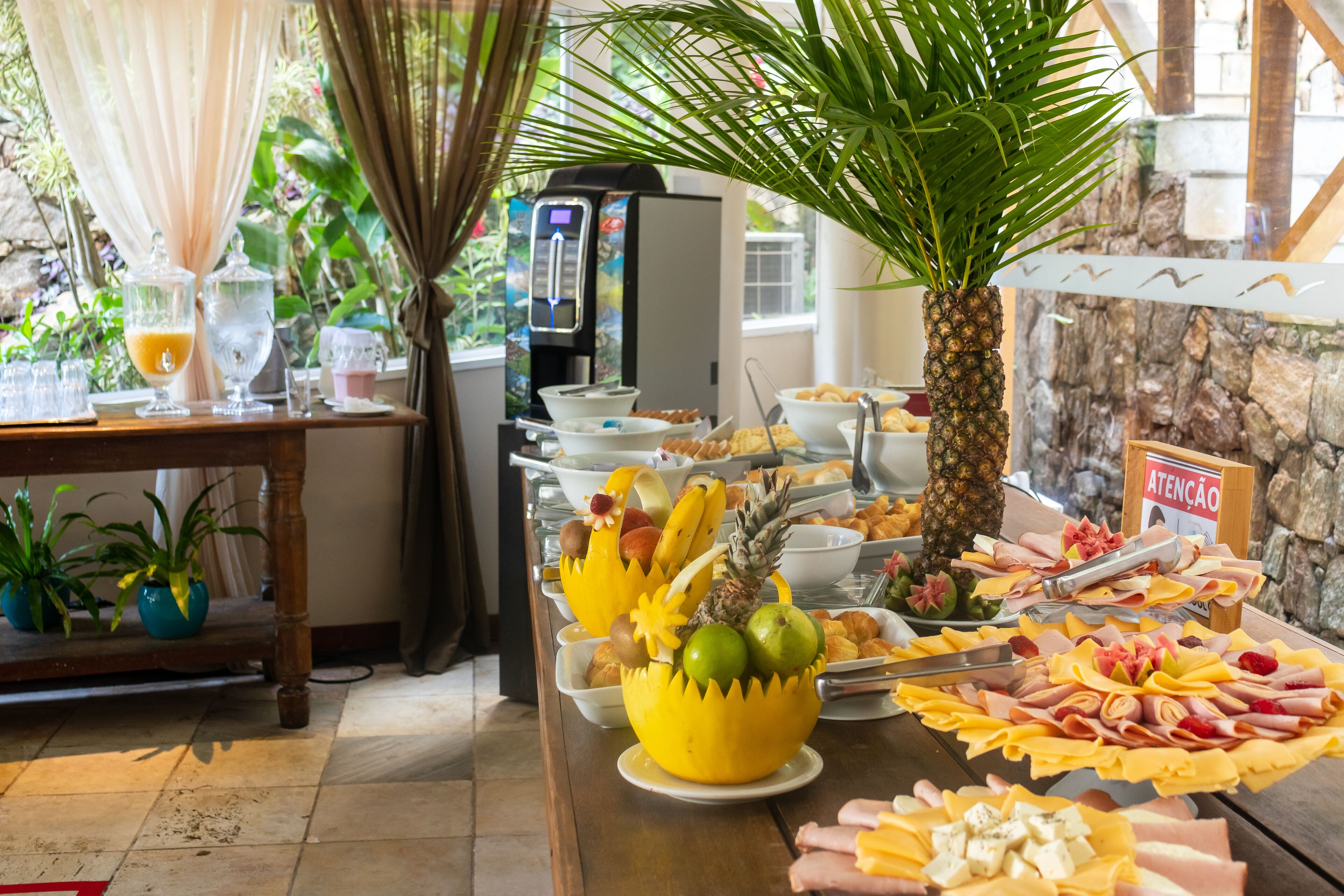 Un buffet proposant divers plats, un distributeur d’eau et un panneau indiquant « ATTENTION ».