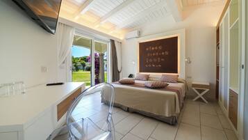 A bedroom with a bed, a desk, a chair, a wardrobe, and a view of the garden.
