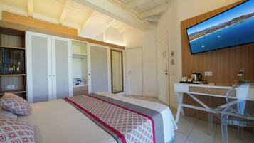 A hotel room with a bed, a desk, a TV, and a wardrobe.