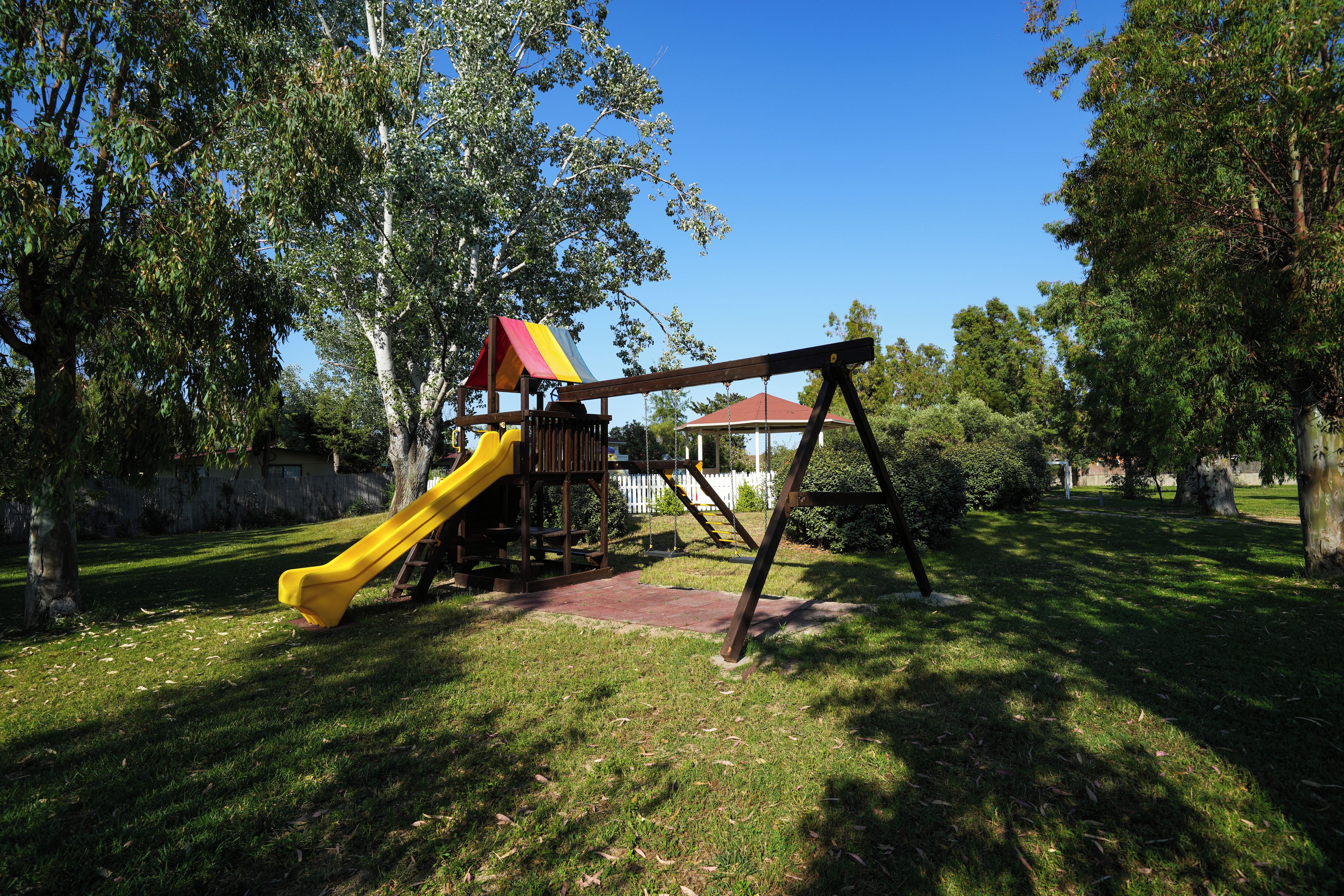Un parque infantil con tobogán y columpios.