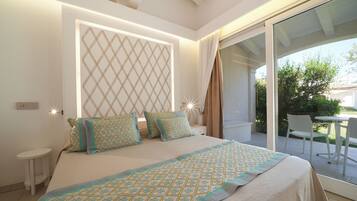 A bedroom with a large bed, a nightstand, a bedside table, and a view of the outdoors through a sliding glass door.