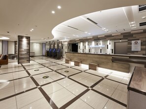 Eine Hotelrezeption mit modernem Design, inklusive Empfangstresen, Sitzbereich und Check-in-Schalter.