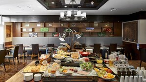 Ein reichhaltiges Buffet mit verschiedenen Speisen und einer Kaffeestation.