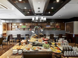 Disposição de buffet com diversos alimentos e um espaço para café.