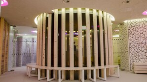 Un spa moderno con una estructura de madera circular, un banco y una pared con diseño.