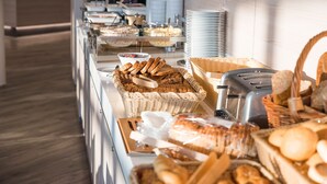 Un bufé con diferentes opciones de comida y utensilios para servir.